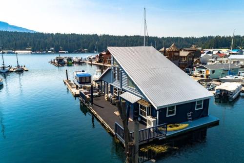 a house on a dock in the water with boats at Charming Waterfront Float Home with Panoramic Lake Views in Athol