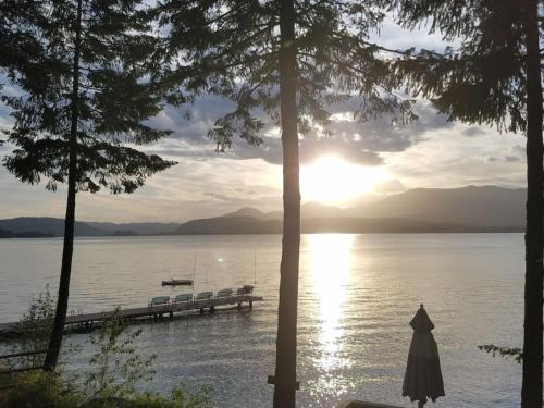 a view of a dock on a lake with a boat at Charming Waterfront Float Home with Panoramic Lake Views in Athol