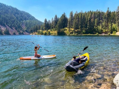 two people are in kayaks on a lake at Charming Waterfront Float Home with Panoramic Lake Views in Athol