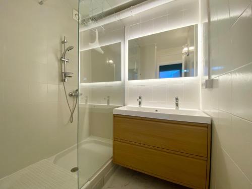 une salle de bain avec un lavabo, une douche et un miroir dans l'établissement Appartement chic & design sur le port, à La Grande Motte