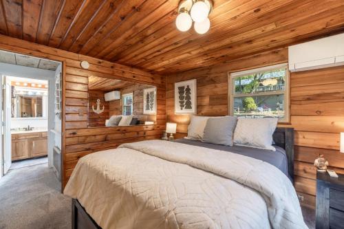 a bedroom with a bed in a room with wooden walls at Charming Waterfront Float Home with Panoramic Lake Views in Athol