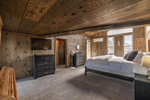 a bedroom with a bed and a flat screen tv at Charming Waterfront Float Home with Panoramic Lake Views in Athol