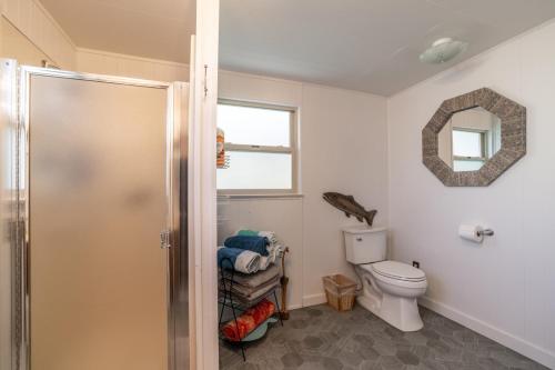 a bathroom with a toilet and a mirror at Charming Waterfront Float Home with Panoramic Lake Views in Athol