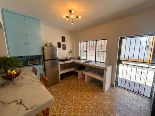 a kitchen with a refrigerator and a table in it at Depas Azules Zona Centro Apt B in Mazatlán