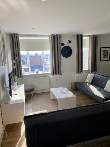 a living room with a couch and a table at Rooftops Apartment in Bletchley