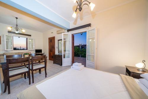 a bedroom with a bed and a desk and a table at Lemonia Apartments Kefalonia in Andipáta Erísou