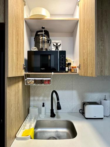 a kitchen with a sink and a microwave at Apartamento Entero 101 in Pereira