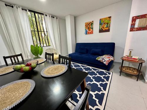 a living room with a table and a blue couch at Apartamento Entero 101 in Pereira