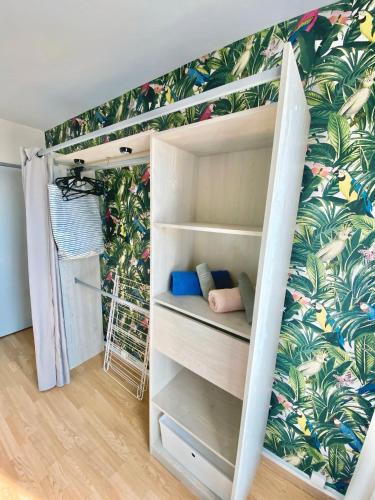 - une chambre avec des lits superposés et du papier peint tropical dans l'établissement Chambre PRIVÉE dans appartement PARTAGÉ - Le Voltaire - Talence - WIFI - REF F1, à Talence