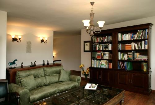 - un salon avec un canapé et une étagère à livres dans l'établissement Hotel Rural Yeguada Albeitar, à Villayón