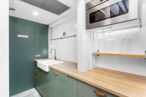 a kitchen with a sink and a microwave at Nest on Newcastle - T3 in Perth