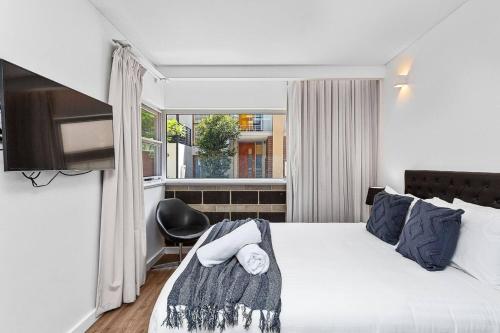a hotel room with a bed and a window at Nest on Newcastle - T2 in Perth