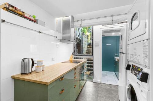 a kitchen with a counter and a washer and dryer at Nest on Newcastle - S4 in Perth