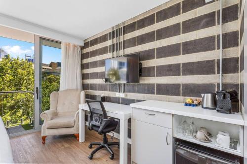 a kitchen with a desk and a chair and a window at Nest on Newcastle - N5 in Perth