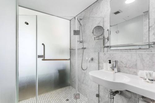 a bathroom with a sink and a shower at Nest on Newcastle - E4 in Perth