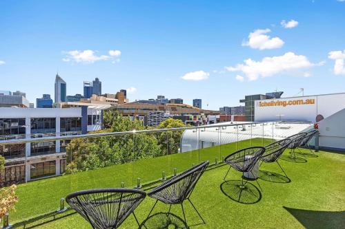 a group of chairs sitting on top of a green roof at Nest on Newcastle - E2 in Perth