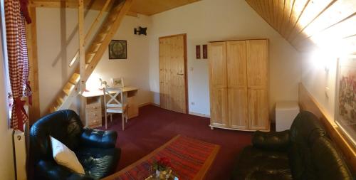 un salon avec un canapé et un bureau et un escalier dans l'établissement Penzion u Dvou studní, à Šumperk