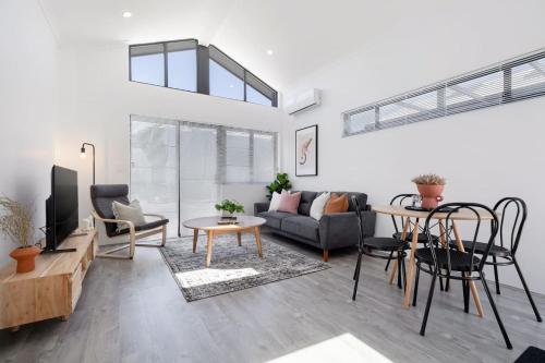 a living room with a couch and a table at Living luxe in Yokine - King bed and FREE parking in Perth