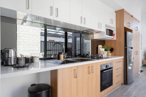 a kitchen with a sink and a stove at Living luxe in Yokine - King bed and FREE parking in Perth