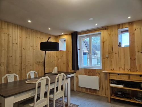 - une salle à manger avec des murs en bois, une table et des chaises dans l'établissement Cœur de Sologne, à Loreux