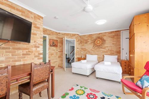 a room with a bed and a desk and a tv at Endless Summer - The Reefs in Perth