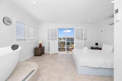 a white bedroom with a bed and a view of the ocean at Sea La Vie - The Watch in Perth