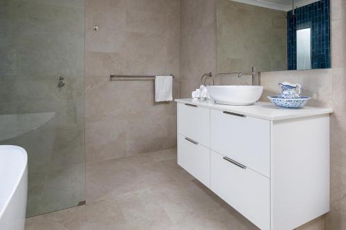 a bathroom with a white sink and a shower at Endless Summer - The Reefs in Perth