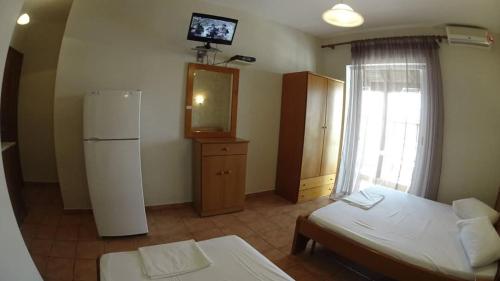 a room with a refrigerator and a tv on the wall at Villa Marina Neoi Poroi in Nei Poroi