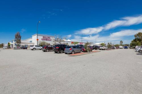 a parking lot with cars parked in front of a store at A8 - Enjoy a romantic weekend at cozy studio apt in Perth