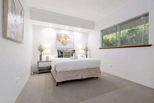 a white bedroom with a bed and a window at A6 - Work-from-home haven - free WIFI - 1BR in Perth