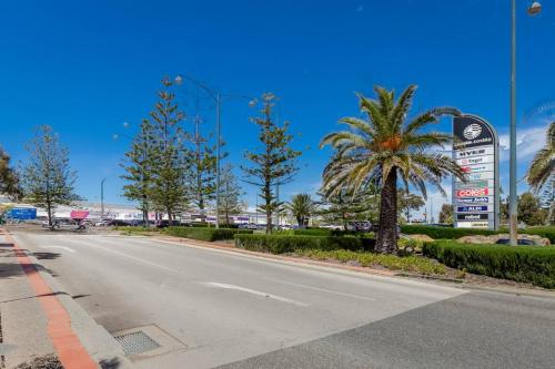 an empty street with a palm tree on the side of the road at A6 - Work-from-home haven - free WIFI - 1BR in Perth