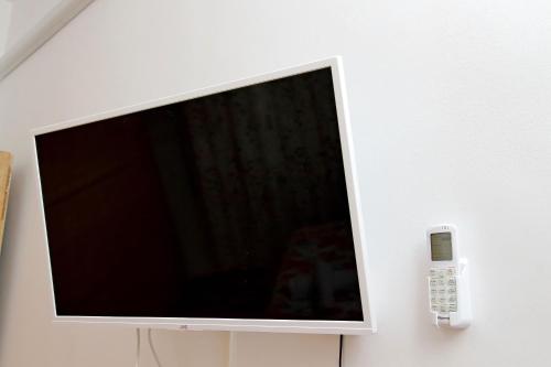 a flat screen tv on a wall with a remote control at Stella Polare Sensorial Home in Lido di Ostia