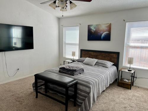 a bedroom with a bed and a flat screen tv at Paradise Skies in Albuquerque