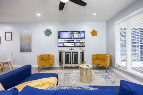 a living room with a blue couch and a tv at Midtown Modern Apt w Arcade 8 miles to FT Moore in Columbus
