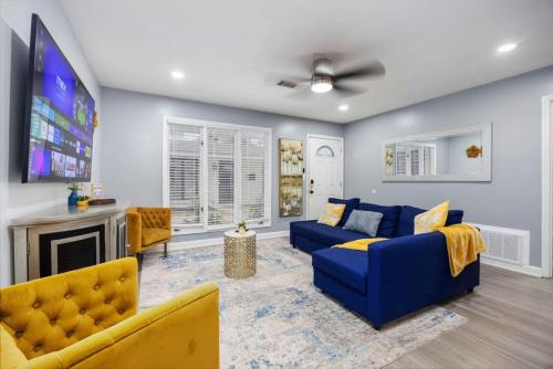 a living room with a blue couch and a tv at Midtown Modern Apt w Arcade 8 miles to FT Moore in Columbus