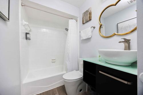 a bathroom with a sink and a toilet and a mirror at Midtown Modern Apt w Arcade 8 miles to FT Moore in Columbus