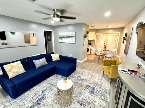 a living room with a blue couch and a table at Midtown Modern Apt w Arcade 8 miles to FT Moore in Columbus