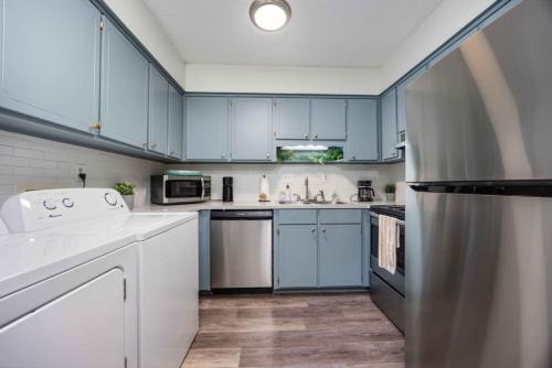 a kitchen with blue cabinets and white appliances at Peaceful APT by Lakebottom w Arcade 8mi Ft Moore in Columbus