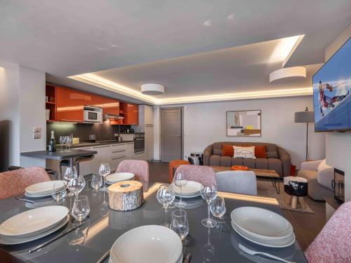 Il comprend un salon avec une table à manger et une cuisine. dans l'établissement Appartement 3 pièces en rénovation – Grand salon épuré à Courchevel Moriond, proche remontées mécaniques - FR-1-563-7, à Courchevel