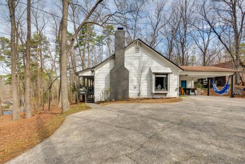 a white house with a chimney and a driveway at 3 Mi to Marietta Square Hot Tub Haven with 2 Patios in Marietta