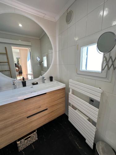 une salle de bain avec un lavabo et un miroir dans l'établissement Superbe Triplex vue panoramique sur Saint-Tropez, à Cogolin