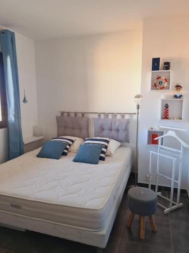 une chambre avec un grand lit avec des oreillers bleus dans l'établissement Superbe Triplex vue panoramique sur Saint-Tropez, à Cogolin