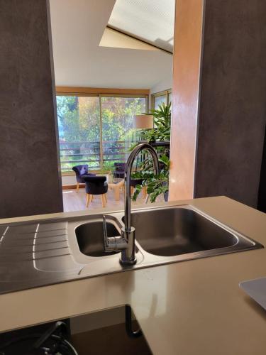 un comptoir de cuisine avec un évier et une fenêtre dans l'établissement Bas de villa plus piscine Vue époustouflante, à Villefranche-sur-Mer