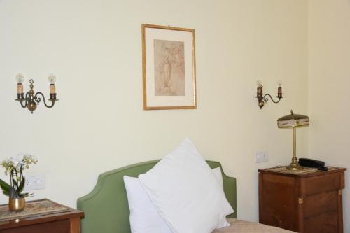 a bedroom with a bed with a pillow and a picture on the wall at Casa Santa Birgitta in Lugano