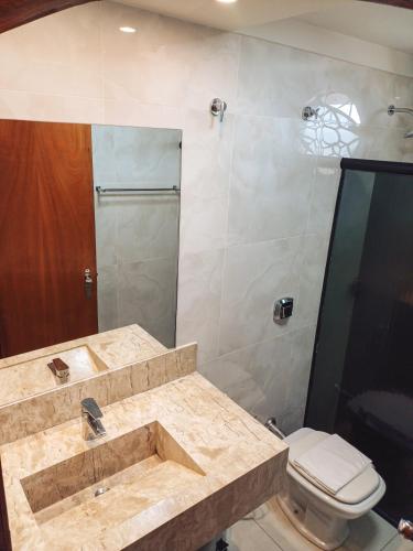 a bathroom with a sink and a toilet at Piloes Palace Hotel in Mineiros