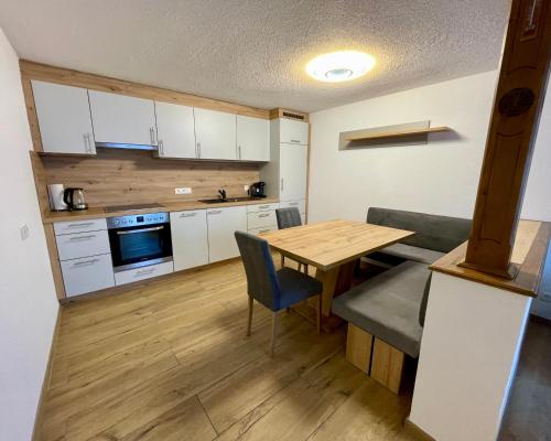 a kitchen with a wooden table and a dining room at Rosumerhof in Leutasch