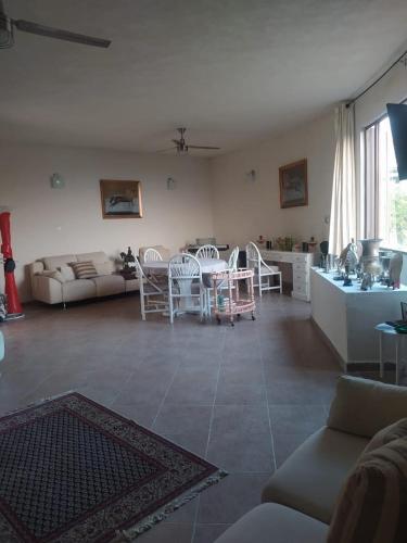 a living room with a table and chairs and a kitchen at Casa Roma in Mango