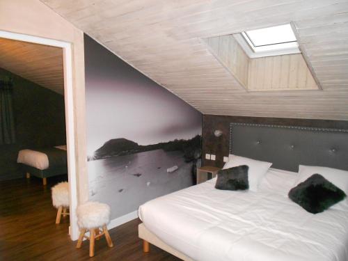 a bedroom with a large bed with a skylight at Cit'Hotel Avantici Gap in Gap