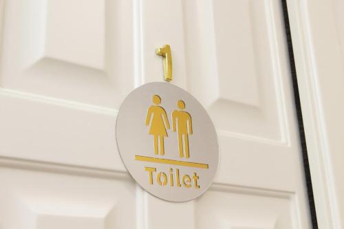 a toilet sign hanging on a door at Stella Polare Sensorial Home in Lido di Ostia