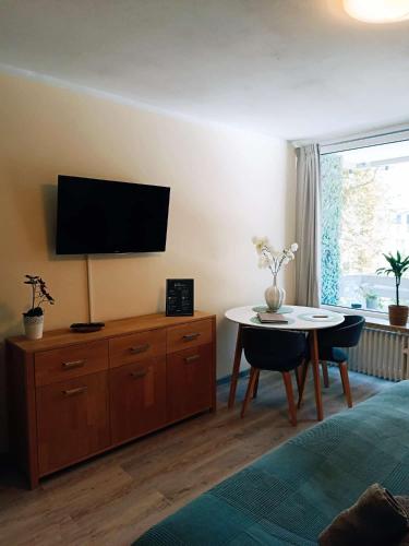 a bedroom with a table and a tv on the wall at Apartment Harzgeflüster in Bad Harzburg
